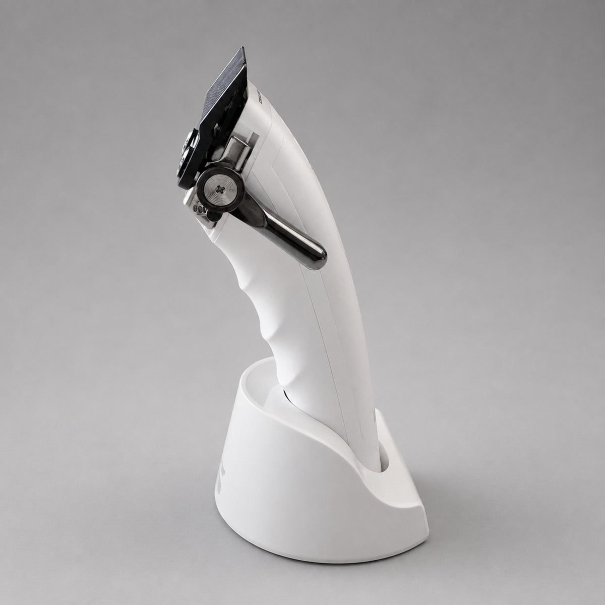 Three-quarter front view of the white UNKWN Vortex Cyclone Clipper in its charging dock, showing the blade, taper lever and brushless motor window